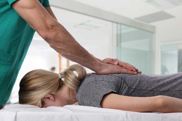A chiropractor speaking with a young family in a bright, comfortable office setting.