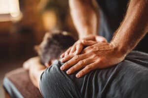 Adult stretching a knee beside a warm compress and a bowl of fresh vegetables at home.