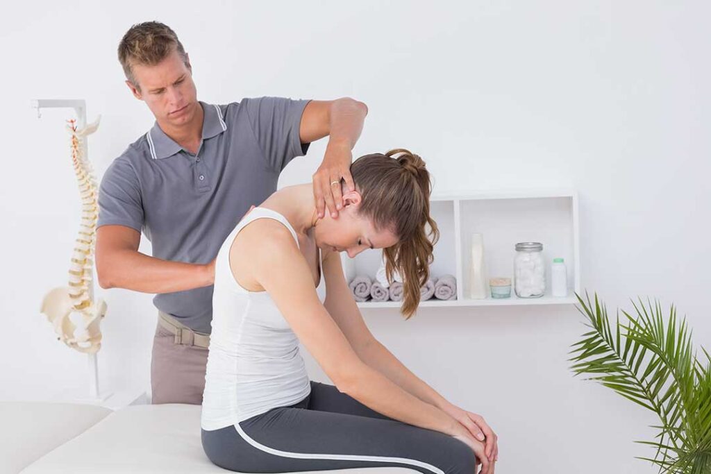 A person receiving a manual back adjustment in a wellness office setting.